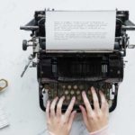 hands typing on a typewriter