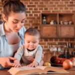 mother and child reading book in the kitchen